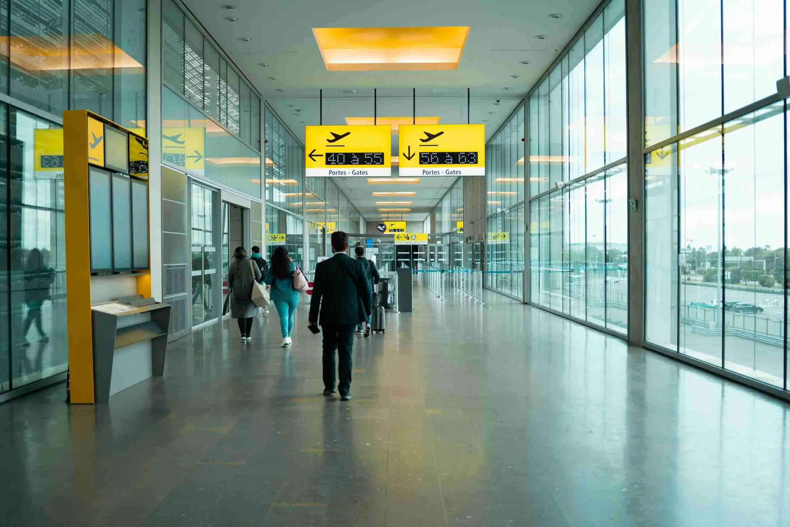 Passengers walking through a bright Madrid-Barajas terminal towards the gates