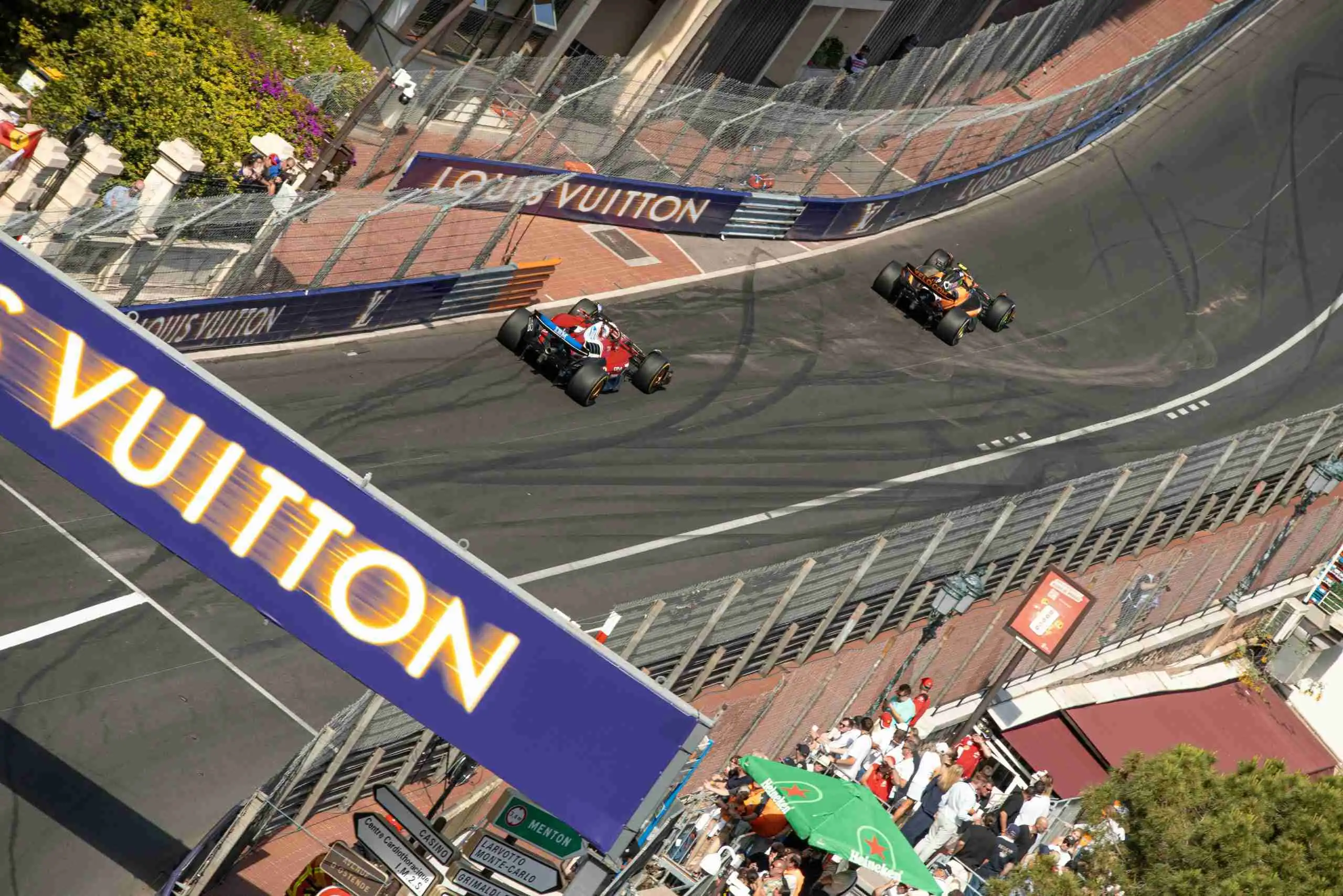 Formula 1 cars racing under floodlights at a street circuit