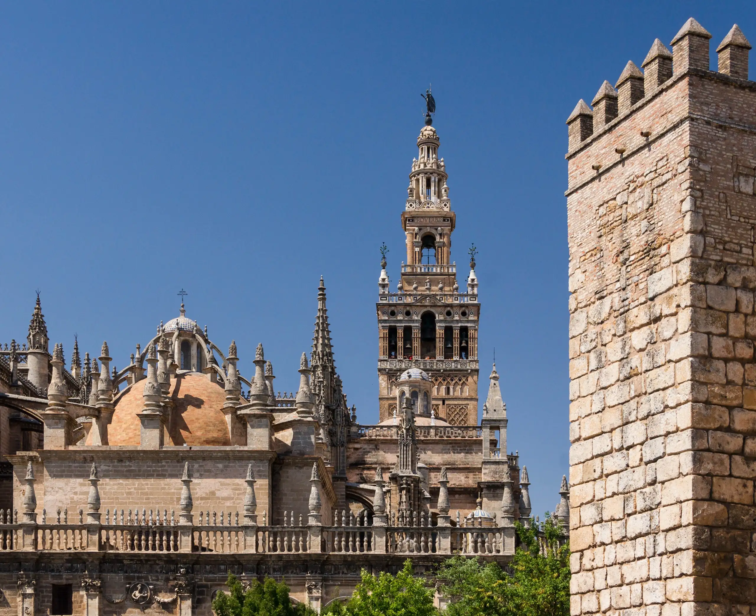 The Giralda and Seville cathedral beside a tower of the Real Alcázar walls